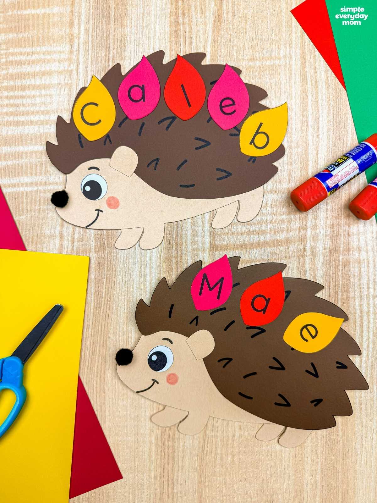 A completed Craft showing two hedgehog name crafts with colorful lettered leaves spelling each child’s name.