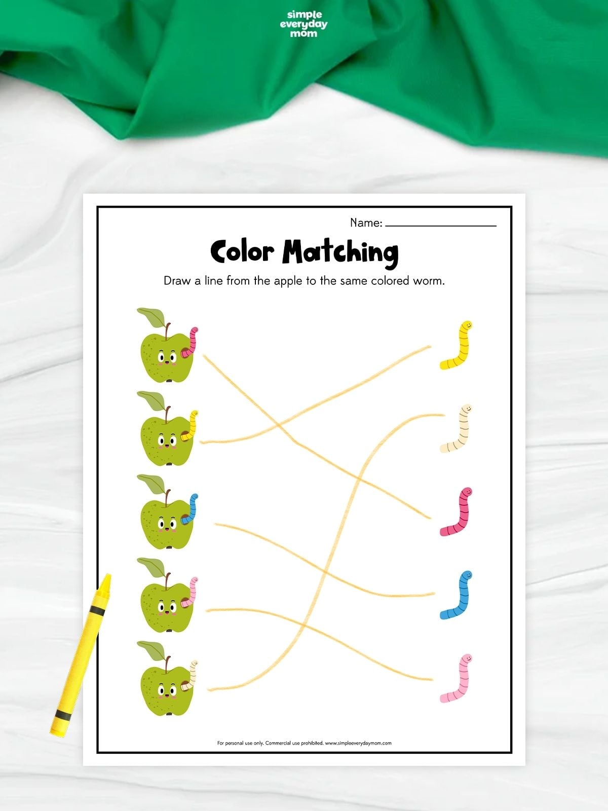 Apple color matching worksheet with five green apples containing colored worms connected by lines to matching yellow, cream, pink, blue, and light pink worms.