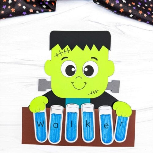 A completed craft showing a Frankenstein holding blue lettered test tubes that spell a child’s name.