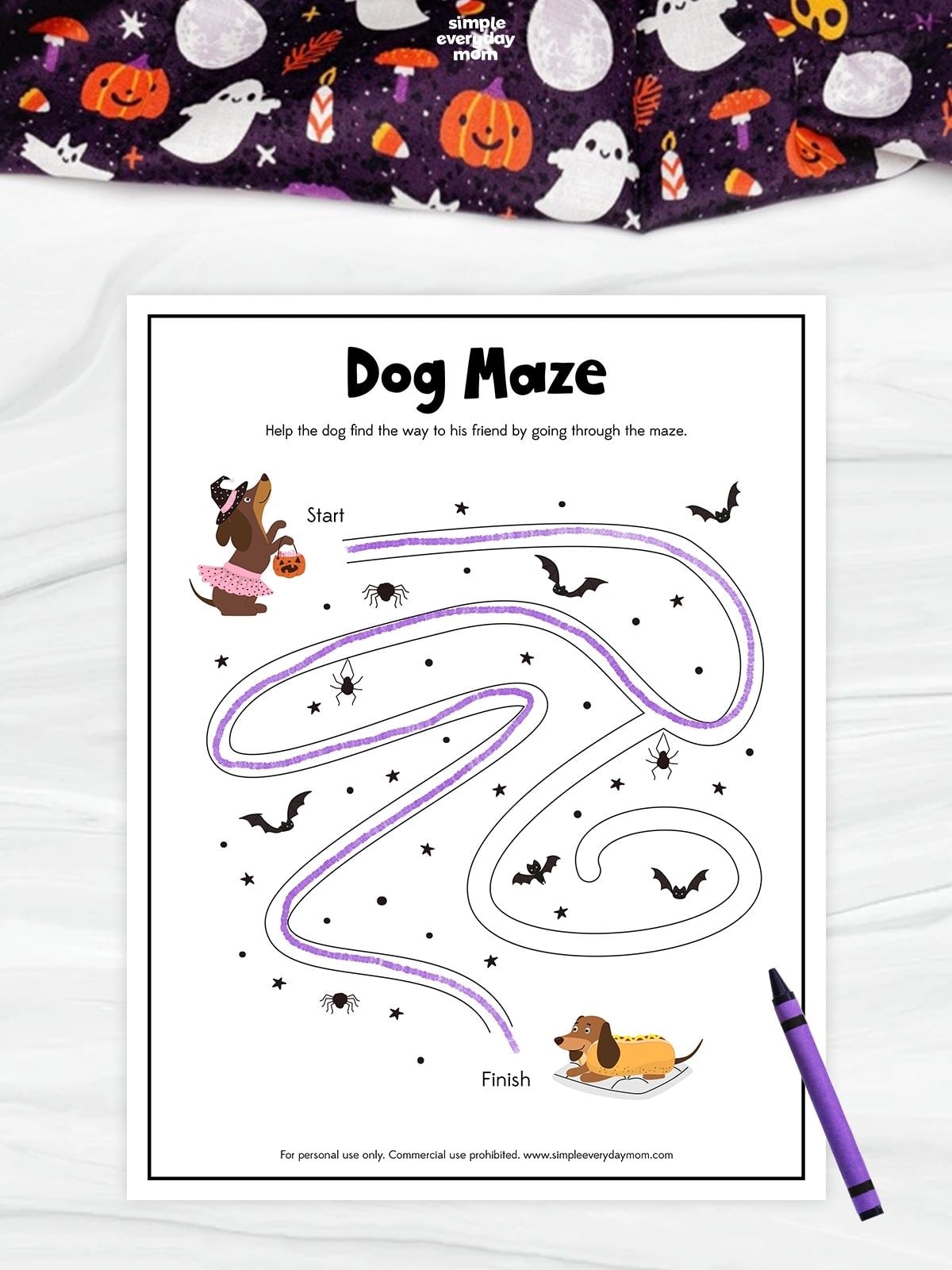Halloween dog maze worksheet featuring cartoon dogs, bats, spiders, and stars. A purple line traces the completed maze from the costumed dog at the start to the hot dog–costumed dog at the finish.