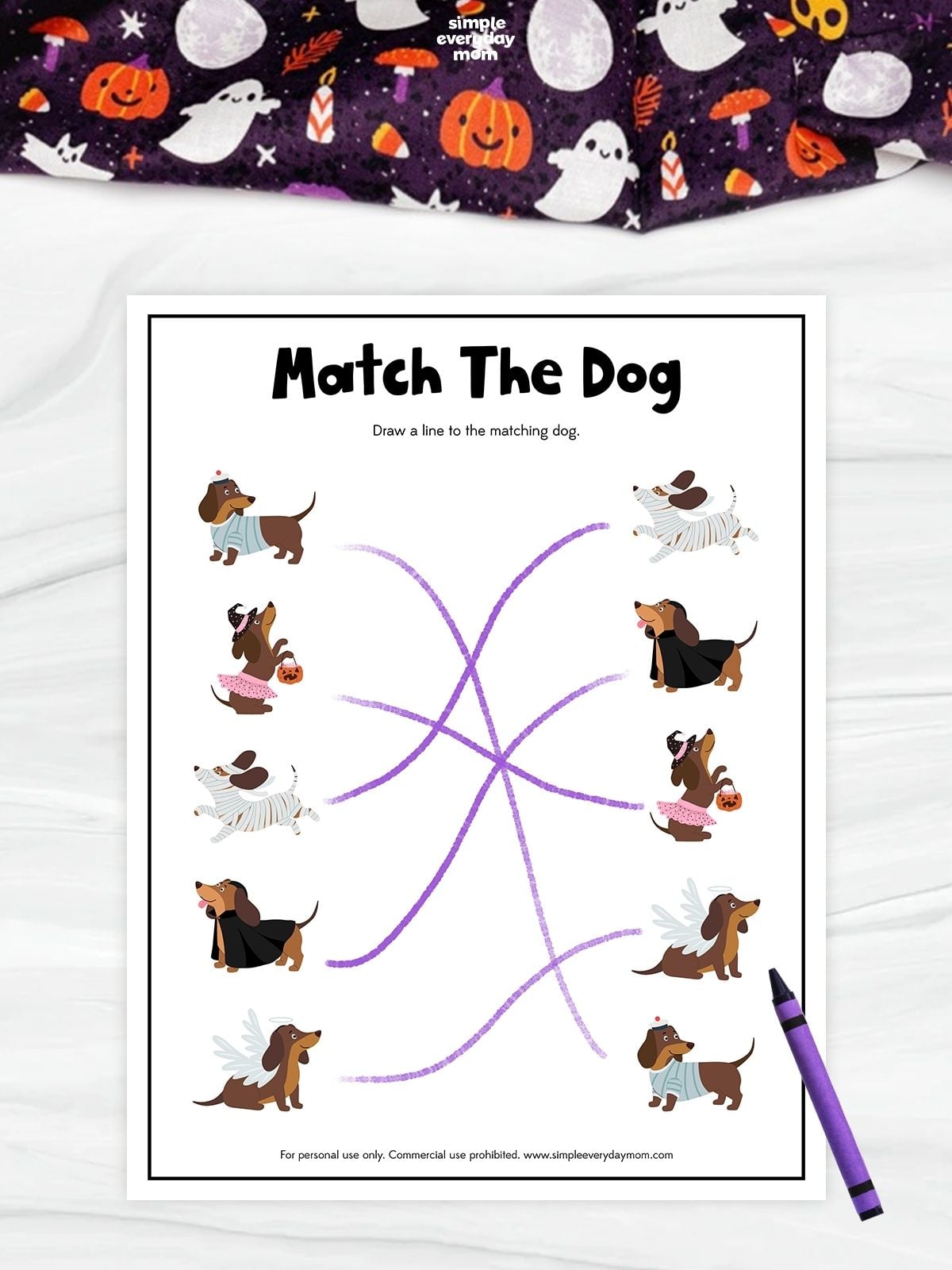 Halloween-themed matching worksheet featuring five pairs of cartoon dogs in different costumes, including a mummy, witch, vampire, angel, and pajamas. Purple lines connect each dog to its matching counterpart.