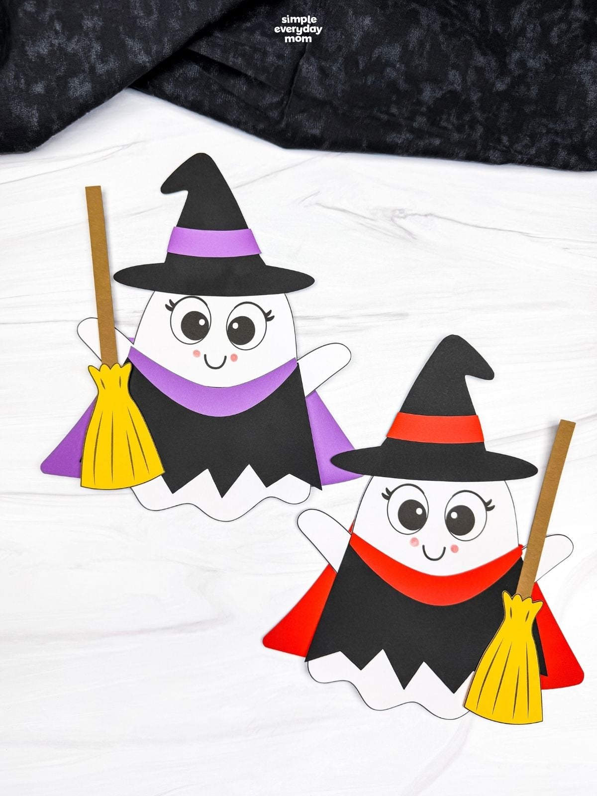 A completed craft showing two Witch Ghost Disguise characters with witch hats, colorful outfits, and brooms.