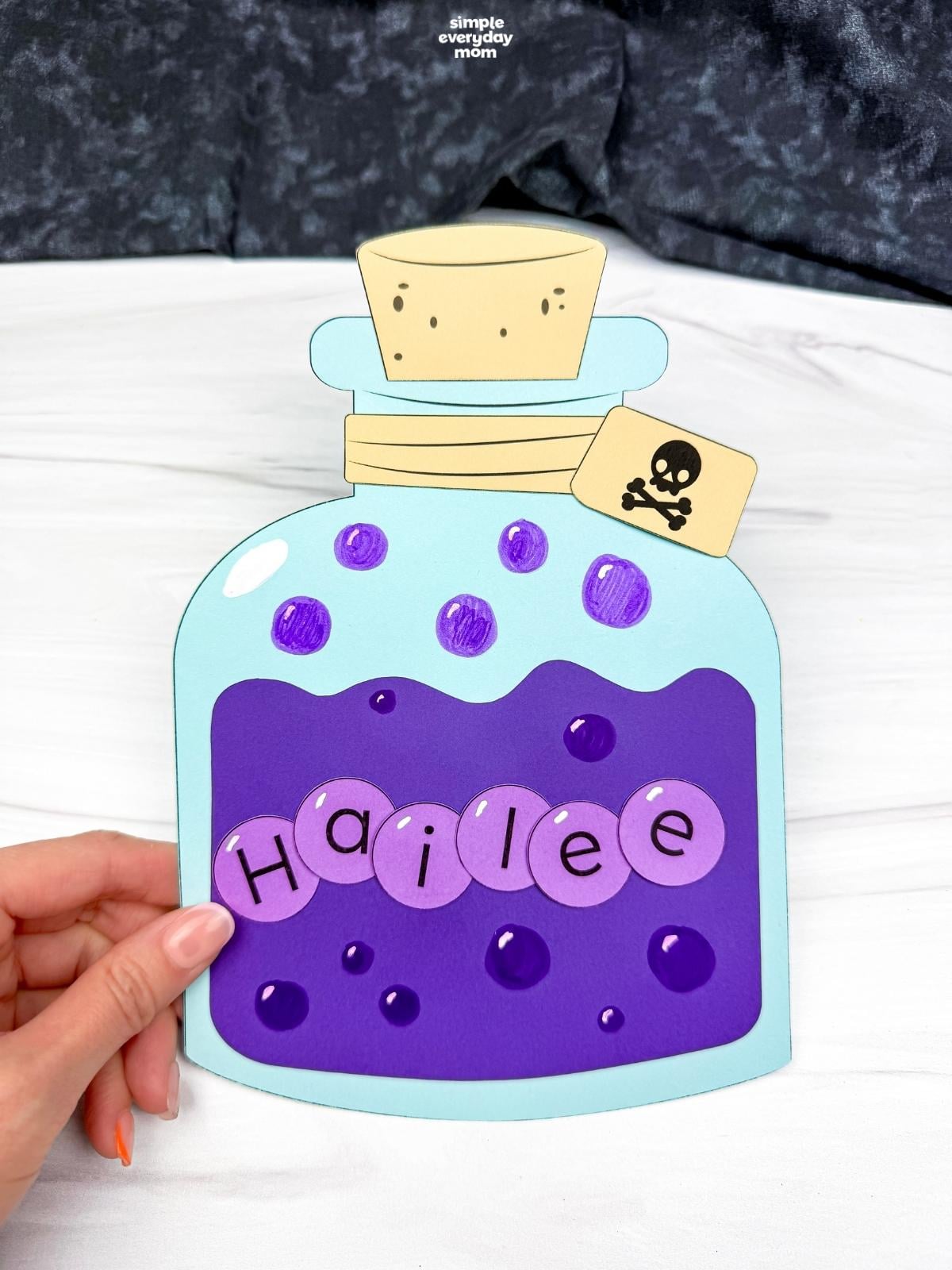 A completed Craft featuring a personalized Halloween potion bottle with bubbles, a cork, and skull tag.
