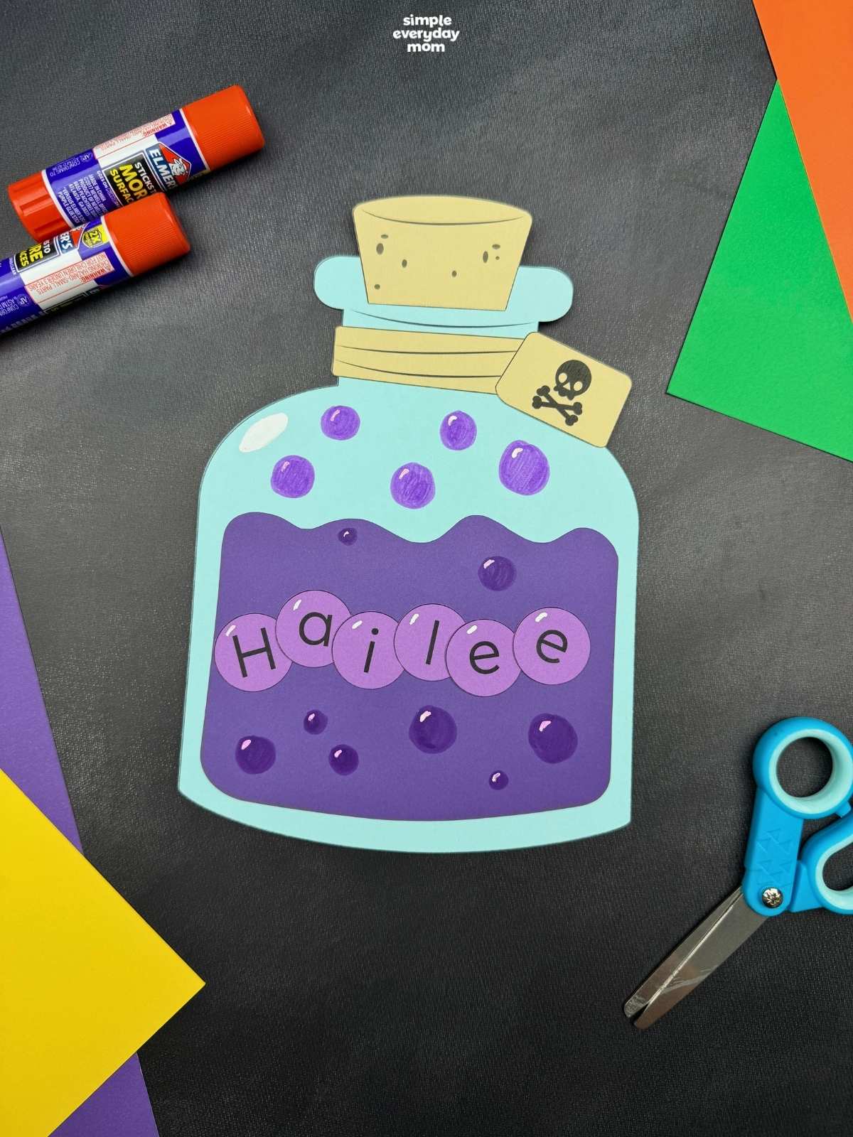 A completed Craft featuring a Halloween potion bottle with a personalized name, bubbles, cork, and skull tag.