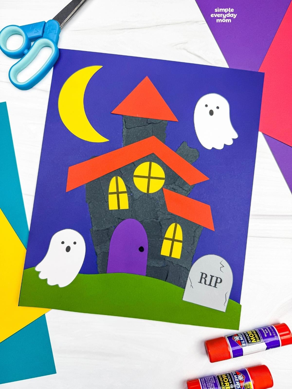 A completed Craft showing a torn paper haunted house with ghosts, a crescent moon, windows, grass, and a headstone.