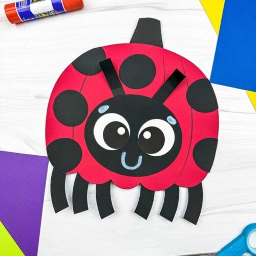 A completed craft featuring a ladybug pumpkin with black spots, a smiling face, antennae, and six legs.
