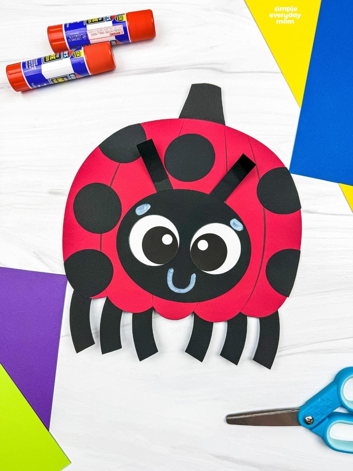 A completed craft featuring a ladybug pumpkin with black spots, a smiling face, antennae, and six legs.