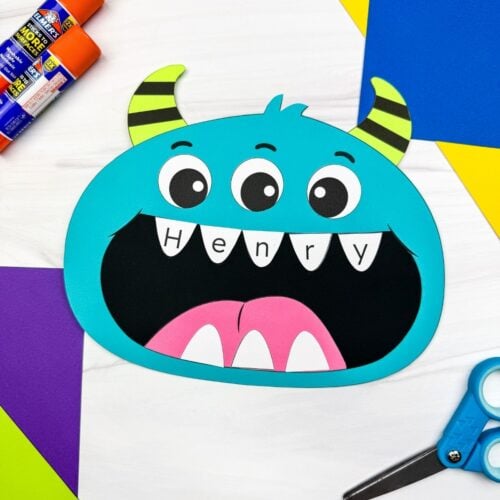 A completed craft featuring a blue monster with three eyes, striped horns, and the name Henry written across its teeth.
