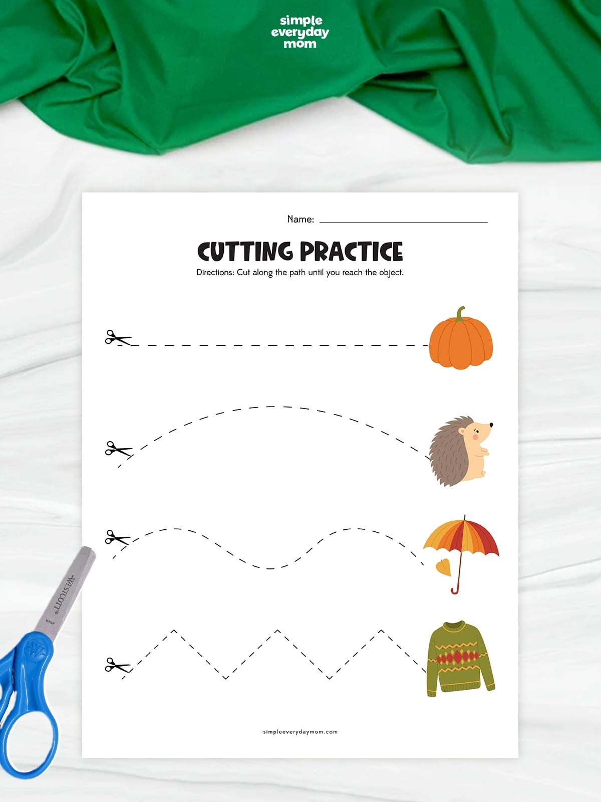Hands cutting along straight, curved, wavy, and zigzag paths toward fall-themed pictures.
