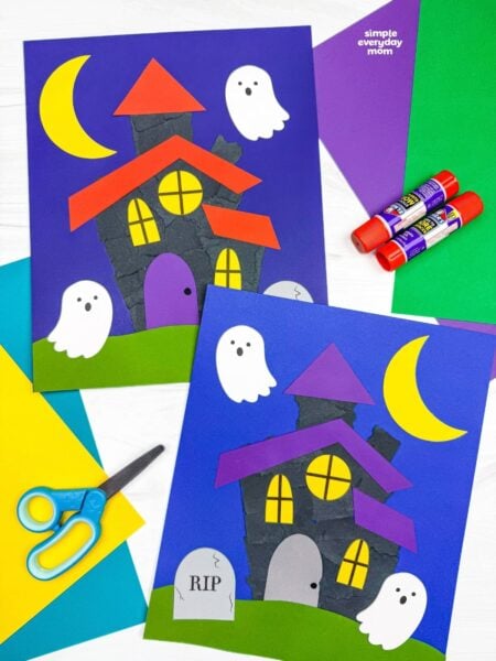 Side by side completed Haunted House Torn Paper Crafts with ghosts, crescent moons, windows, grass, and headstones.