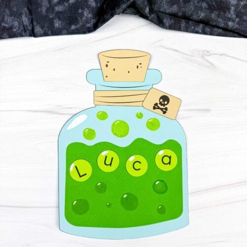 A completed Craft featuring a green Halloween potion bottle with letter bubbles spelling a name, a cork, and skull tag.