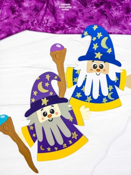 A completed Craft showing two Wizard Handprint Crafts with decorated hats, handprint beards, robes, and wizard staffs.