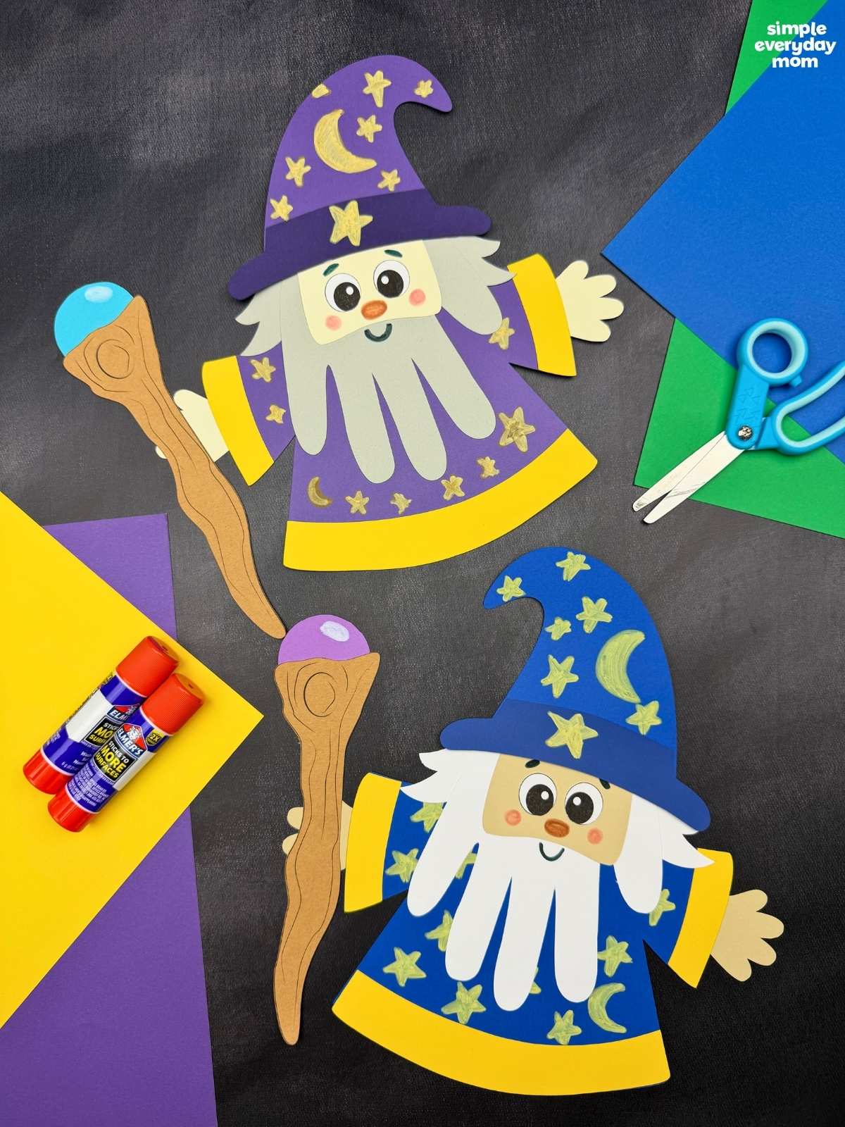 A completed Craft showing two Wizard Handprint Crafts with decorated hats, handprint beards, robes, and staffs alongside craft supplies.