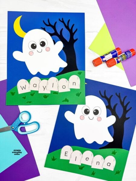 A completed Craft showing two Halloween Ghost Name Crafts with smiling ghosts, crescent moons, spooky trees, and personalized letter tombstones surrounded by colorful paper and craft supplies.