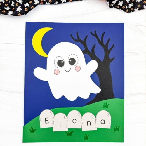 A completed Craft featuring a smiling ghost, crescent moon, spooky tree, and tombstones spelling a child's name for a fun Halloween name recognition activity.