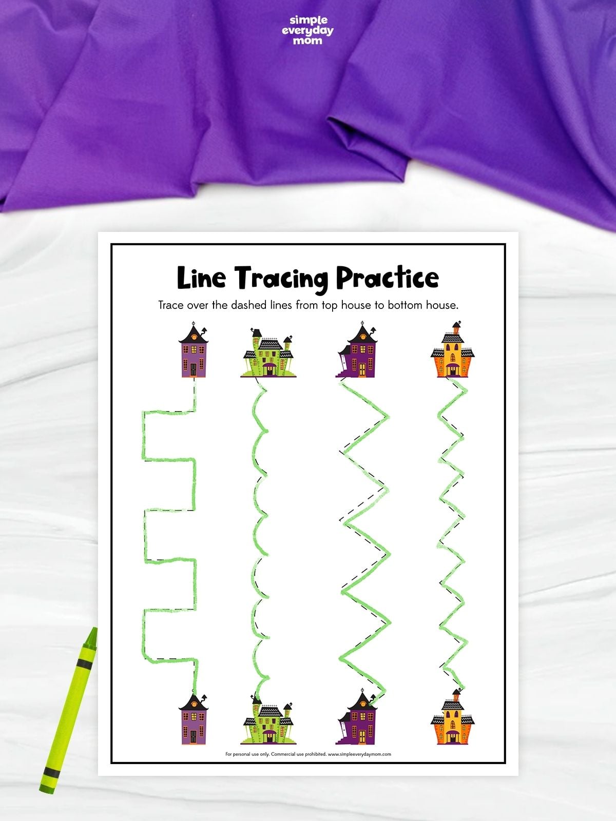 Line tracing practice worksheet featuring four pairs of colorful haunted houses connected by different dashed paths, including stepped, curved, and zigzag lines. The paths have been traced in green from the top houses to the matching houses below.