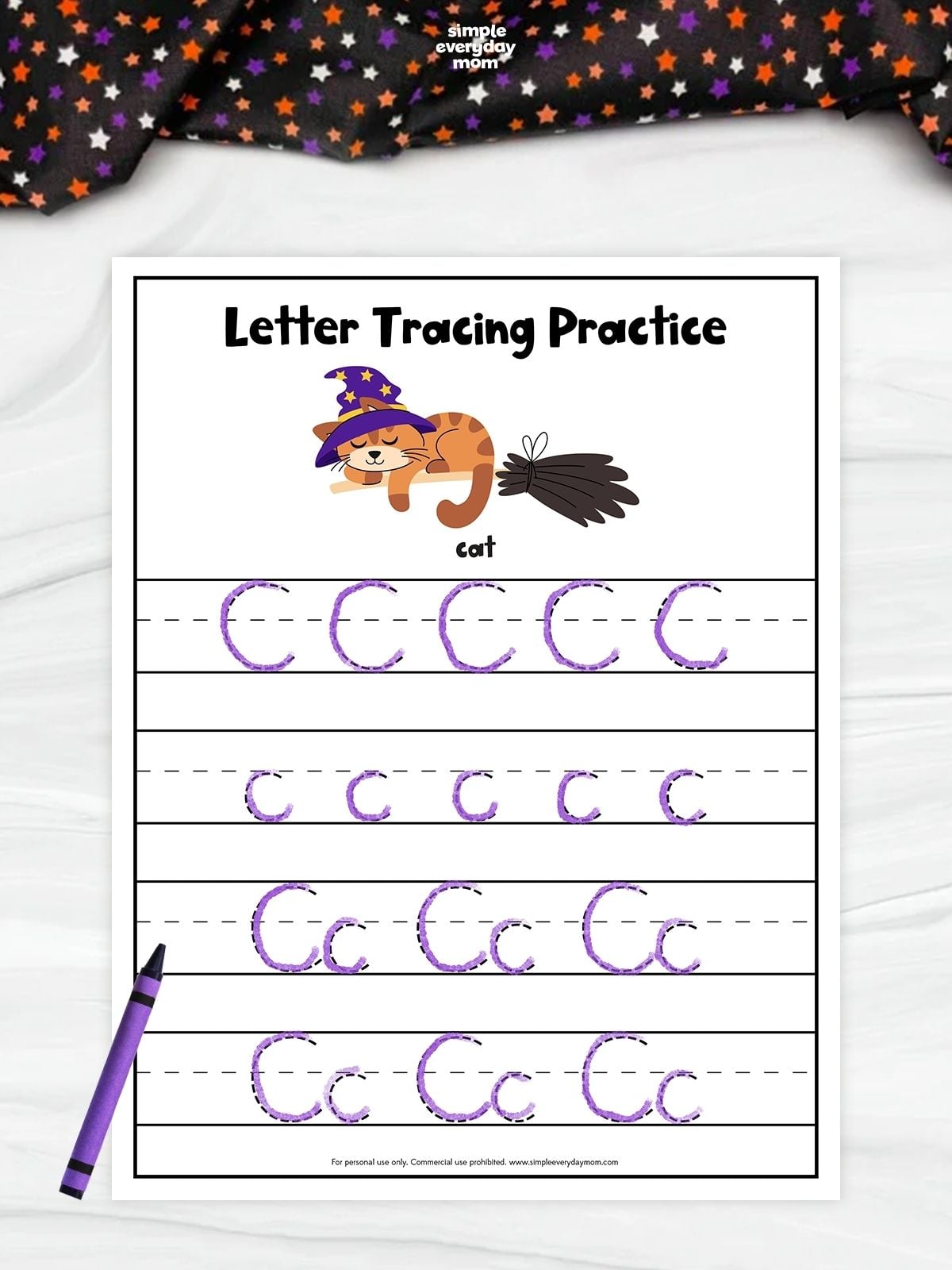 Letter tracing practice worksheet featuring a cartoon cat in a witch hat beside a broom, with rows for tracing uppercase C, lowercase c, and “Cc.” The letters have been traced in purple.