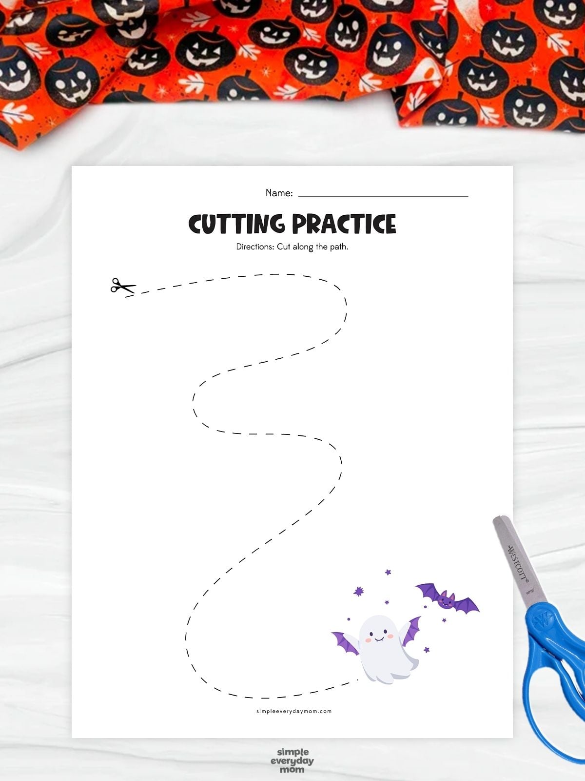 A completed ghost cutting practice worksheet featuring a curved tracing path for kindergarten scissor skills and Halloween fine motor practice.