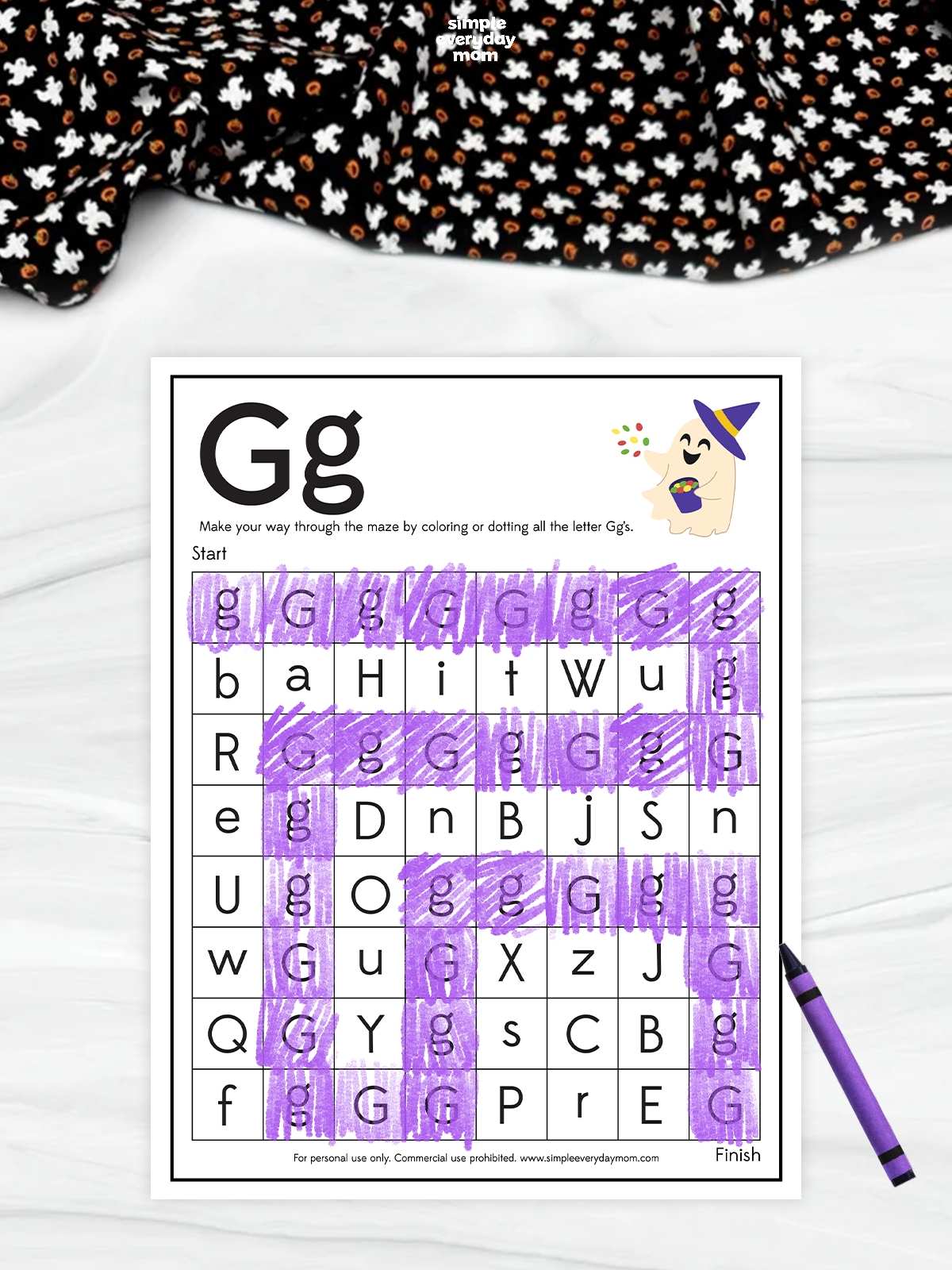A printable Halloween letter G maze worksheet featuring a cute ghost in a witch hat and purple-colored uppercase and lowercase G letters for preschool alphabet recognition practice.